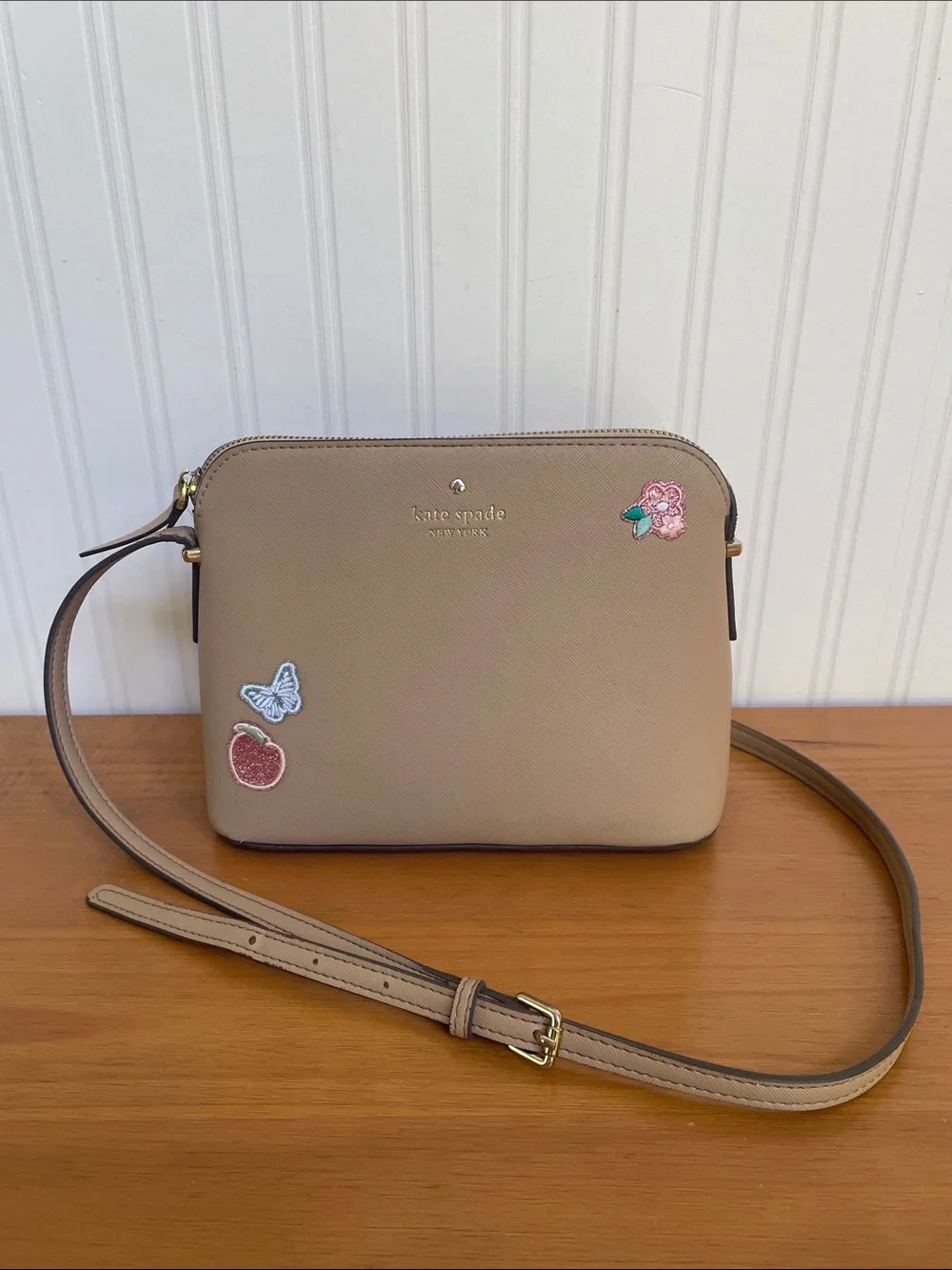 Kate Spade tan crossbody with floral, butterfly and fruit accents